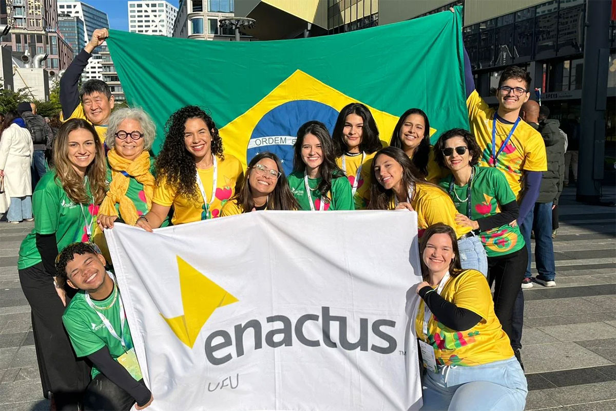 Estudantes brasileiros com a bandeira do Brasil e uma bandeira da Enactus